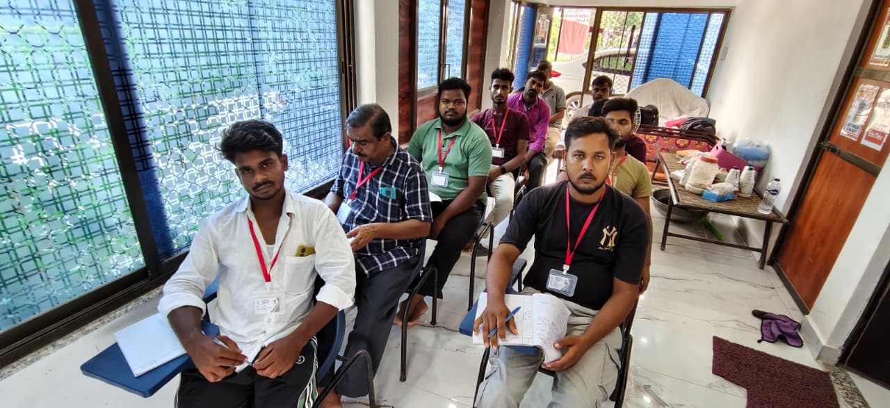 प्रशिक्षण केंद्र की खिड़की के फ्रेम के बगल में खड़े ISO प्रमाणित रजिस्टर लिए हुए सफल सुअर पालन बैच